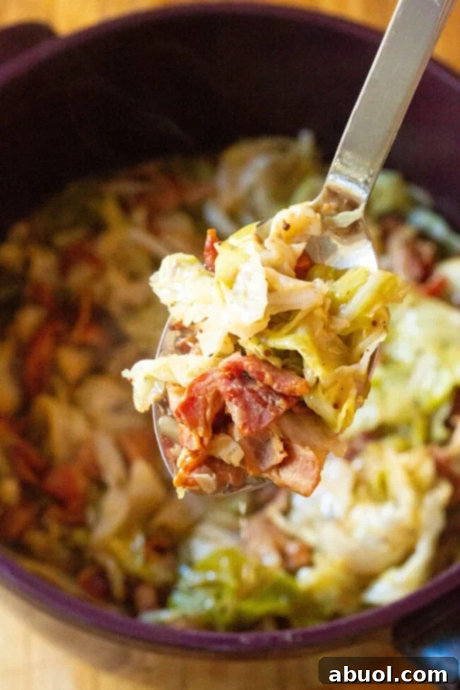 Easy and Flavorful Irish Cabbage and Bacon for Saint Patrick's Day Celebrations A large stock pot filled with delicious Irish Bacon and Cabbage, with a serving spoon lifting a portion.