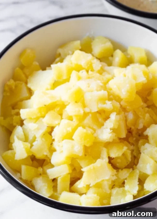 Perfectly cooked and chopped potatoes, some with skins left on, ready to be mixed for potato salad.
