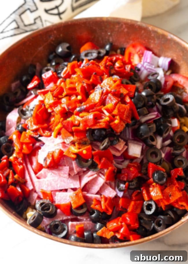 A bowl of uncooked fusilli pasta next to a pint of vibrant cherry tomatoes, ready for preparation.