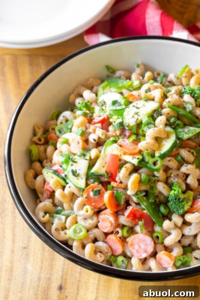 A generous serving bowl of colorful veggie pasta, showcasing a beautiful medley of fresh ingredients and creamy sauce.