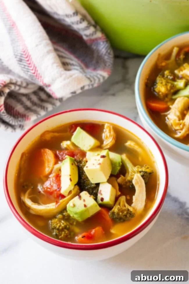 Detox Southwest Chicken Soup Ready to Serve An overhead shot of a steaming bowl of Southwest chicken detox soup, garnished with fresh herbs and a drizzle of healthy oil.