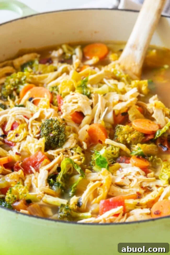 Hearty Chicken Vegetable Detox Soup A large pot filled with steaming detox chicken soup, brimming with a colorful assortment of fresh vegetables and tender chicken.