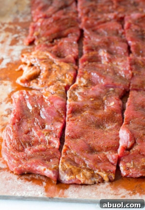 Seasoning and slicing steak for delicious Low Carb Fajita Roll-Ups