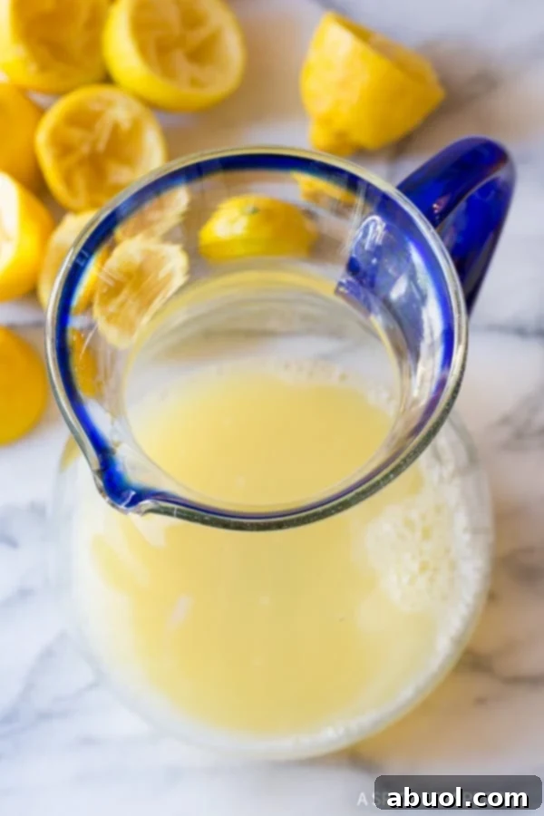 Freshly squeezed lemon juice poured into a large pitcher.