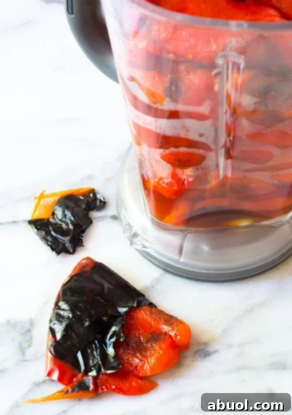 Peeling the roasted red peppers and placing them in a blender. 
