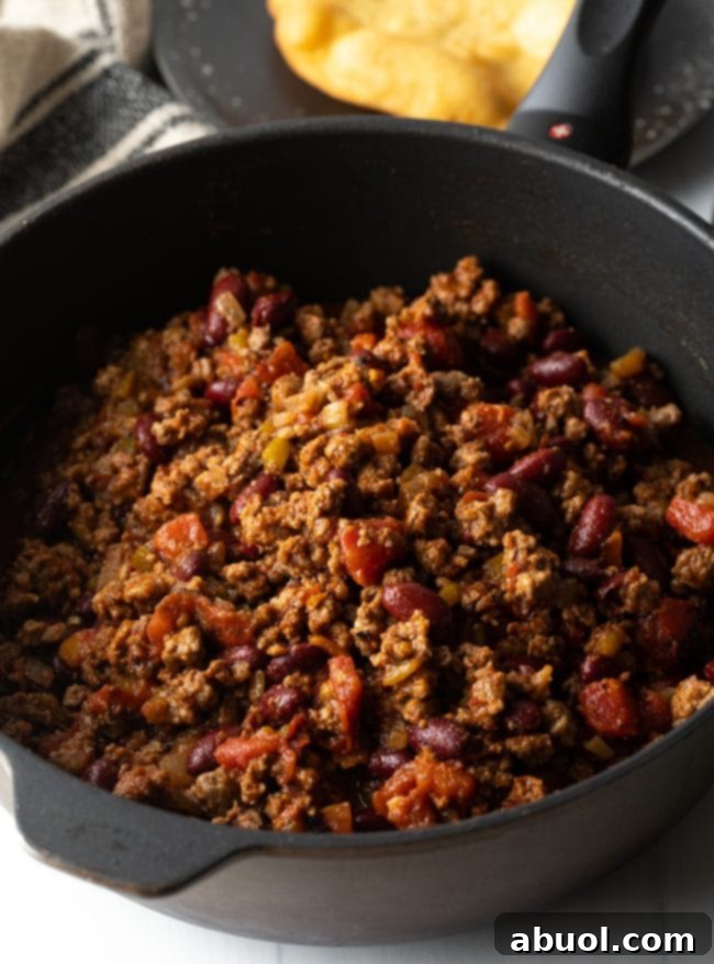 Navajo Taco Meat sizzling in a skillet, rich with spices and vegetables.