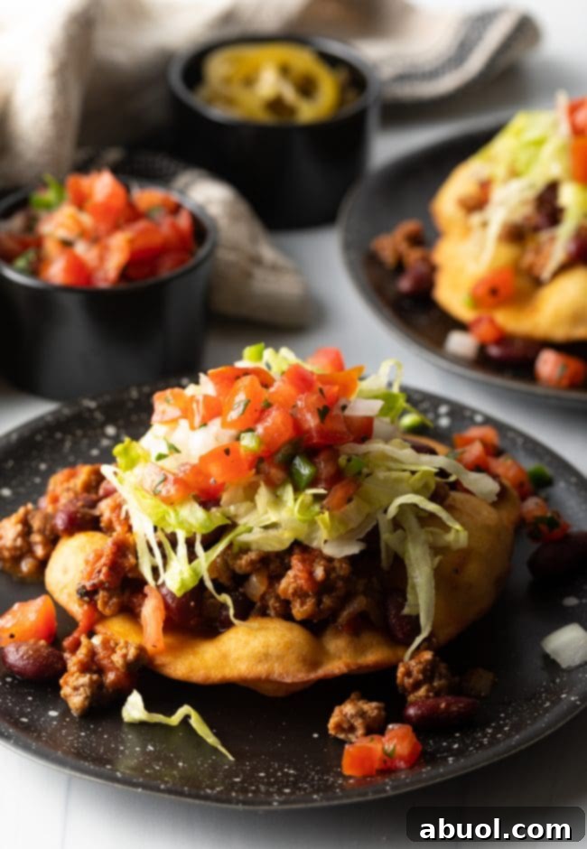 A vibrant Navajo fry bread taco, loaded with colorful taco toppings, presented beautifully.