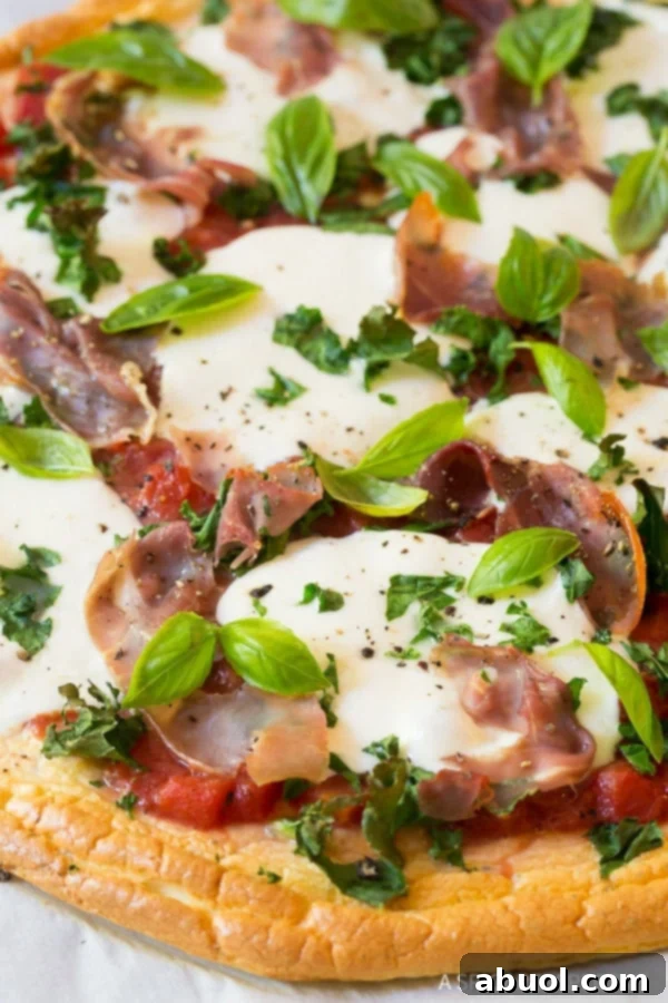 Freshly baked Low Carb Cloud Bread Pizza, golden and bubbly from the oven, garnished with basil.