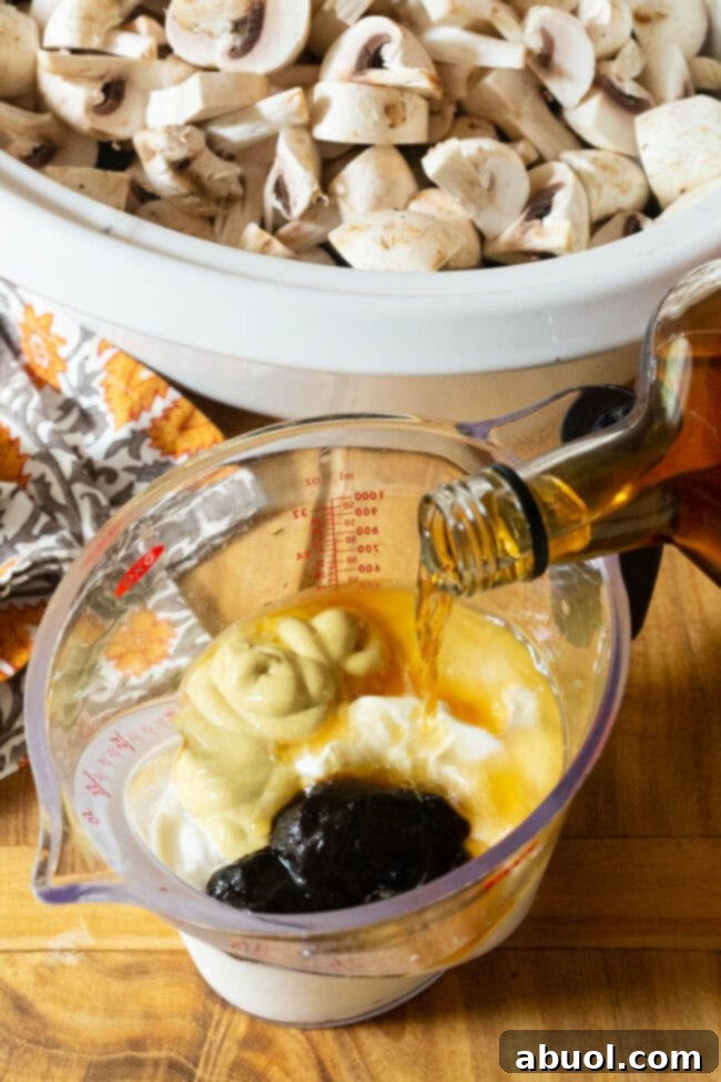 A measuring pitcher containing the rich stroganoff sauce base before adding to the slow cooker.