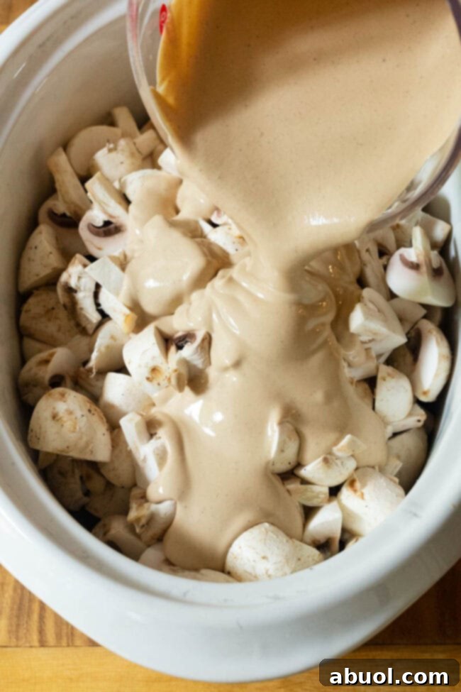 Quartered mushrooms and the prepared sauce base, ready for the slow cooker.