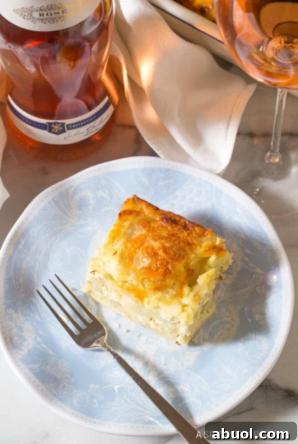 A beautifully plated slice of Croatian Cheese Strukli, served alongside a glass of elegant rosé wine, creating a perfect, inviting meal.