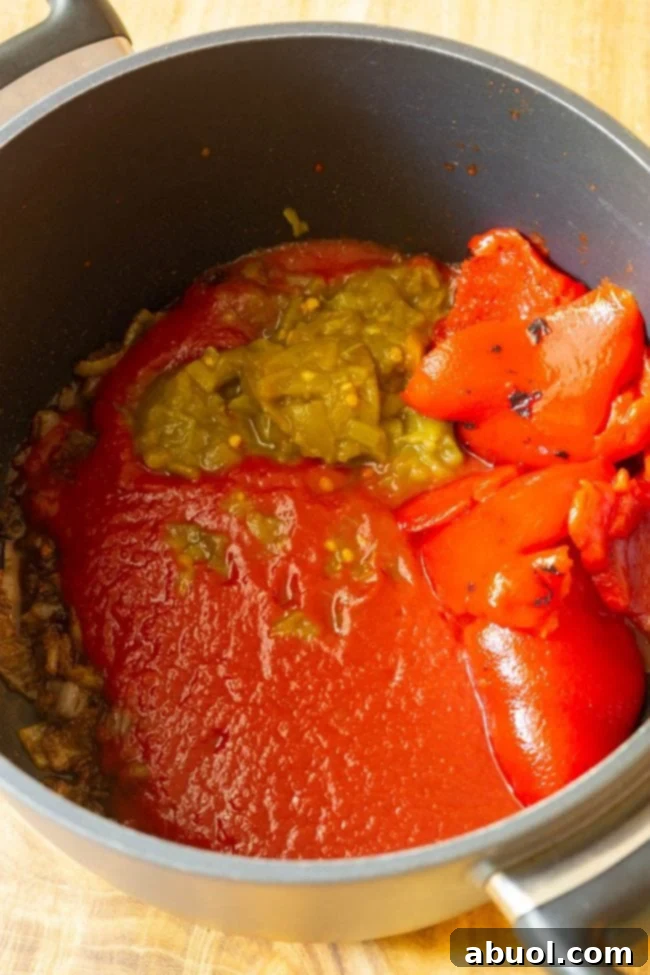Preparing the ranchero sauce, showing vibrant red tomatoes and peppers being blended.