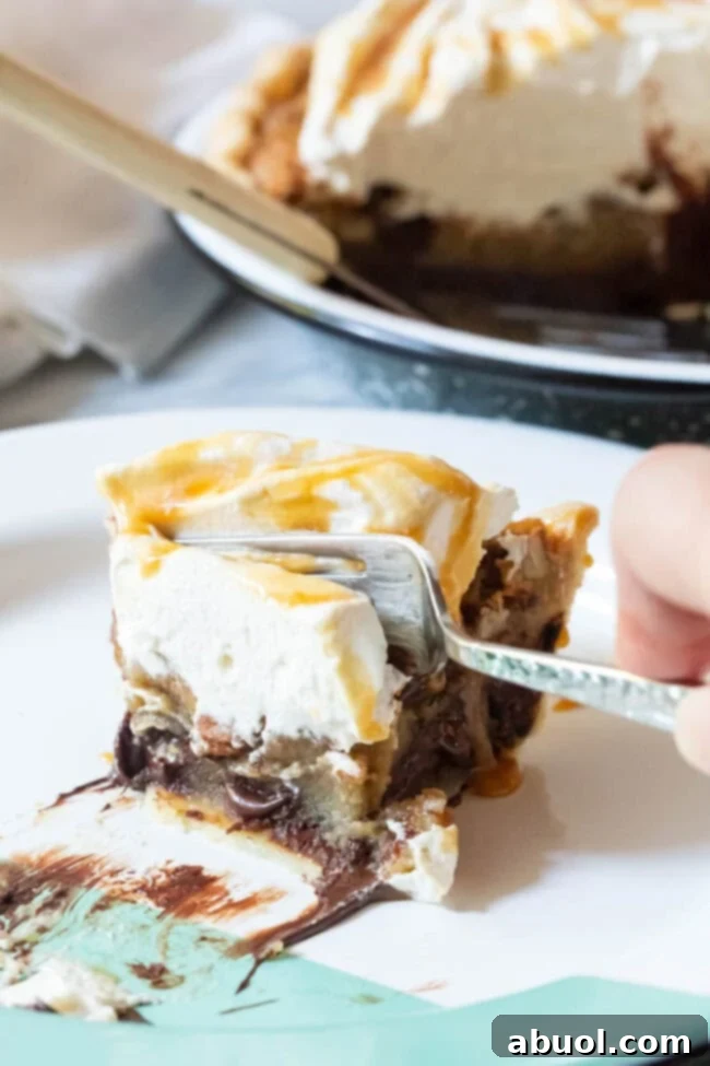 A close-up of a slice of bourbon pecan pie, showing the rich texture of the filling with pecans and chocolate, and a fork ready to take a bite.