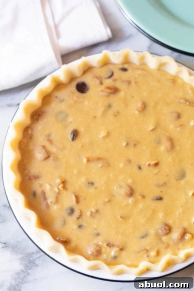 Unbaked chocolate pecan pie filling, rich with bourbon, pecans, and dark chocolate chips, ready in a chilled pie crust.