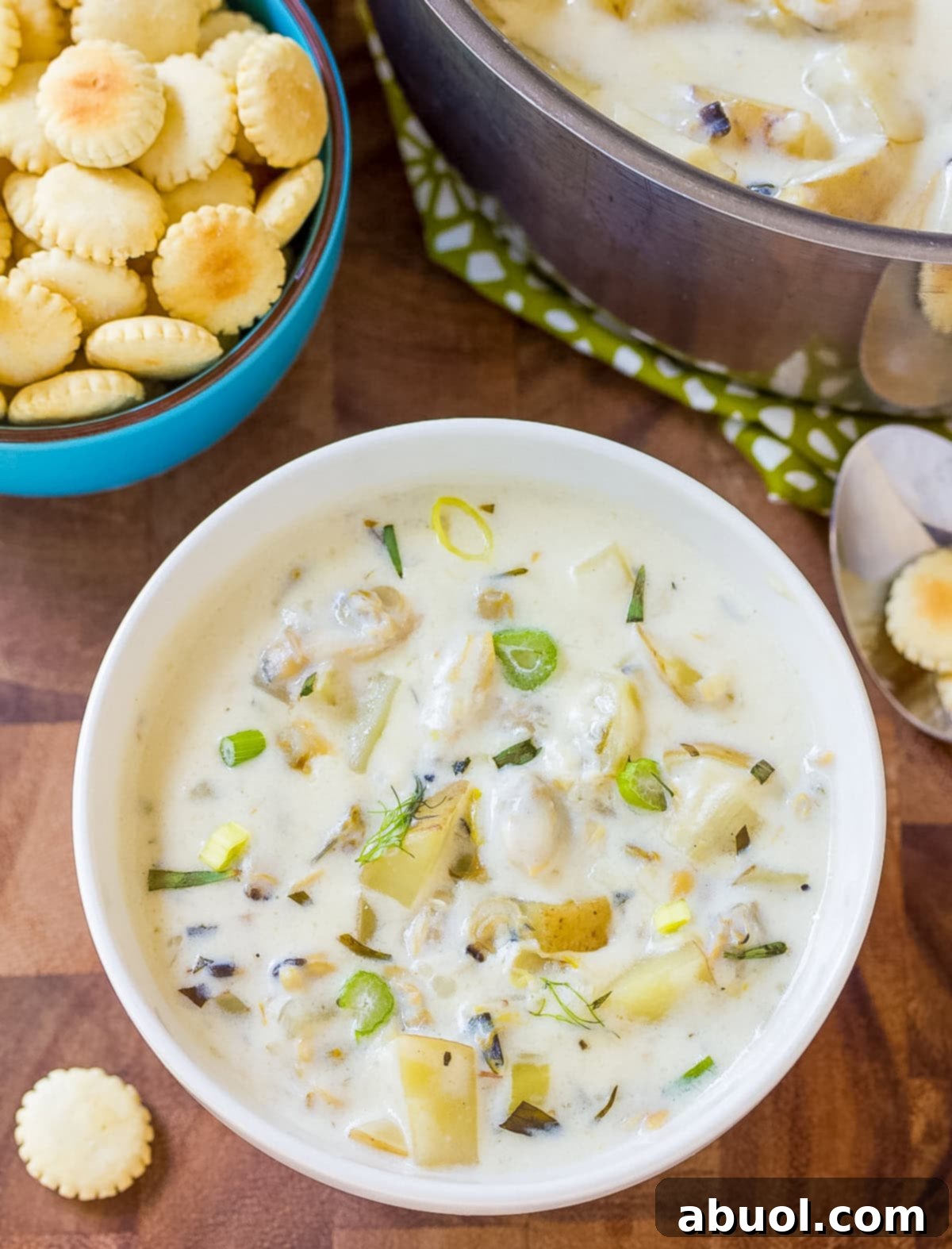 New England Clam Chowder in bowl with crackers and scallions