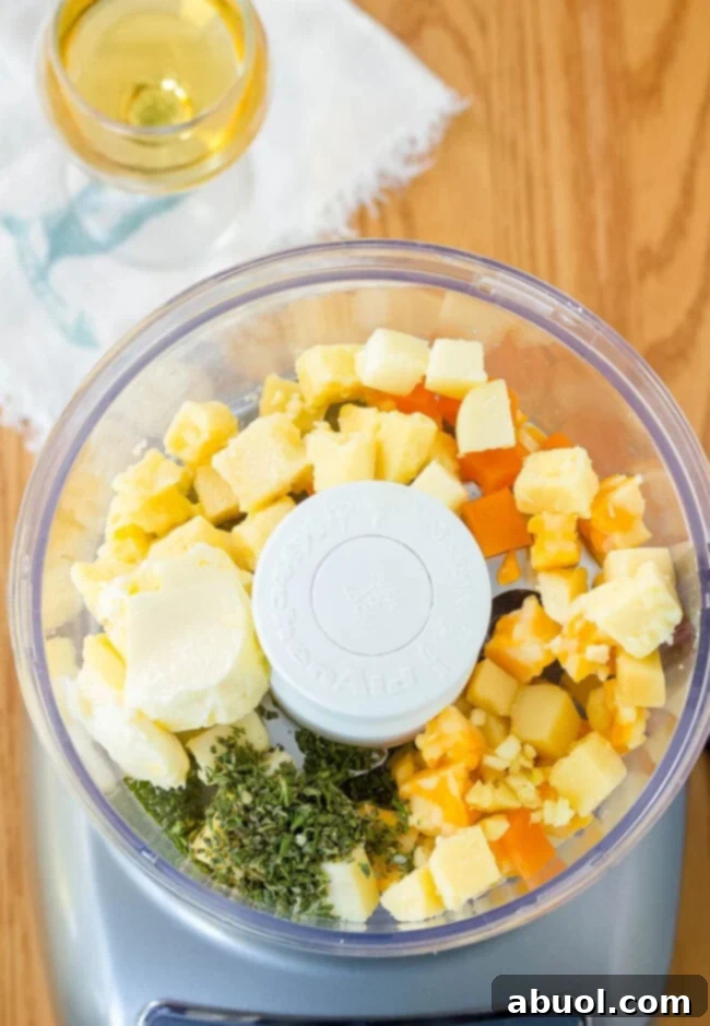 Overhead of cheese and herbs in a food processor.
