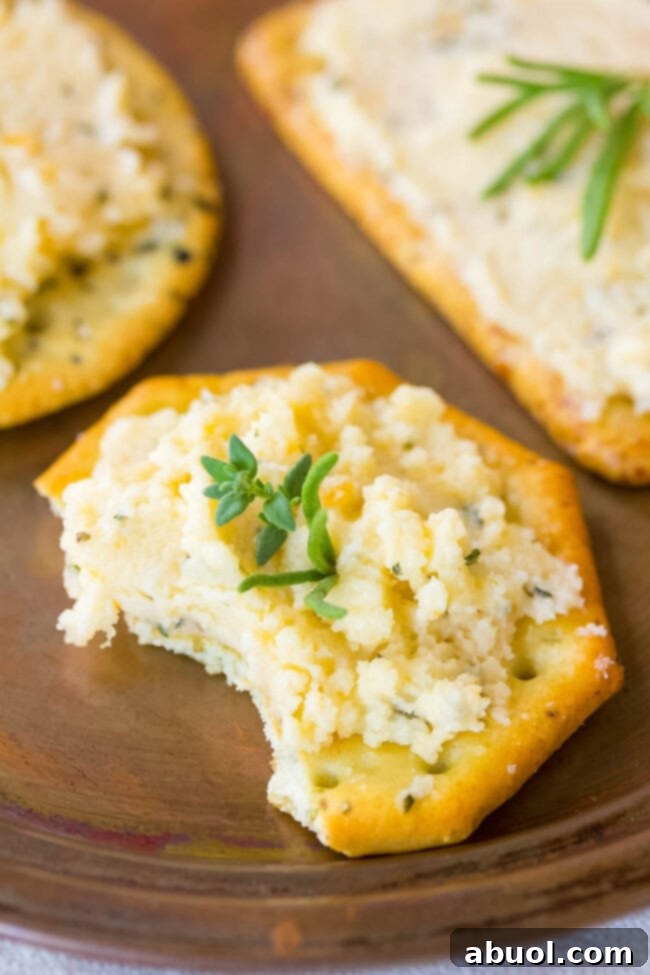 Cheese spread on cracker with a bite taken out. 