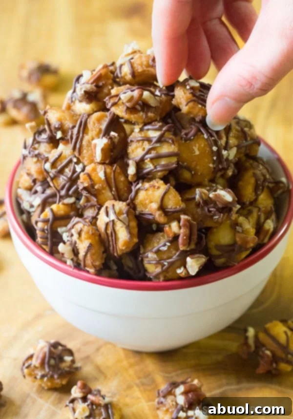 Christmas Crack Recipe #ASpicyPerspective Christmas Crack Candy Recipe in white and red bowl - Picking pieces up with fingers