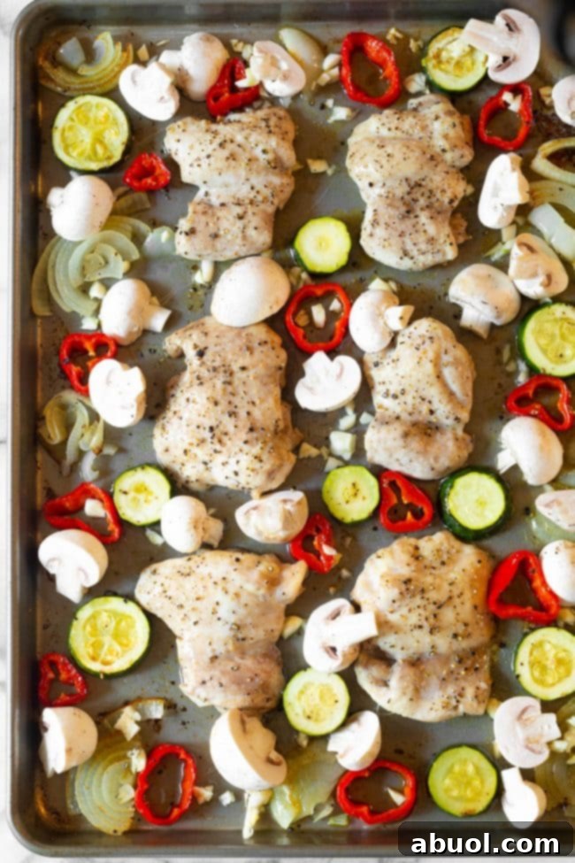 Boneless, skinless chicken thighs seasoned on a sheet pan