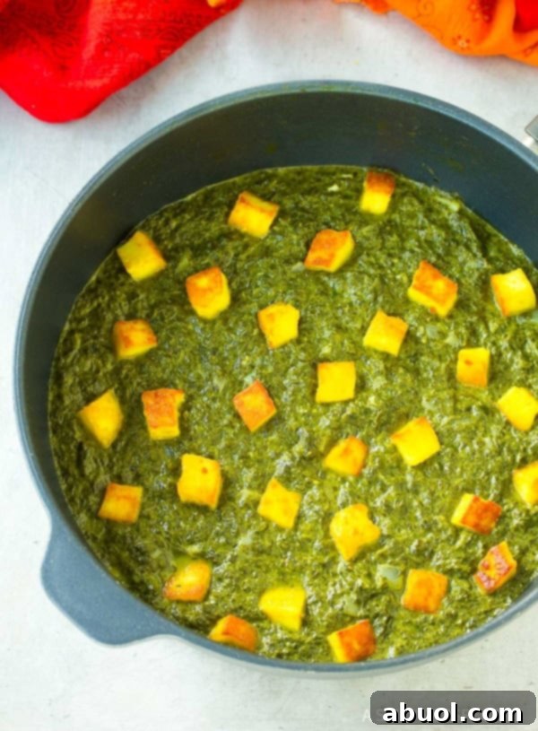 Finished saag paneer simmering in a pot, rich and green.