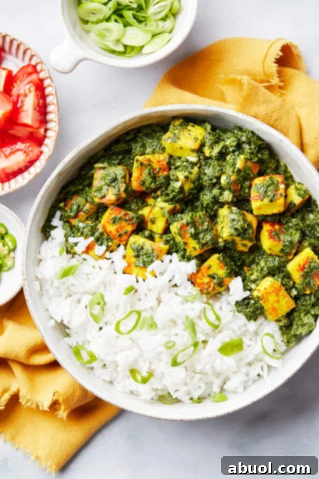 Top-down view of creamy Spinach Saag Paneer in a bowl, showing the rich green sauce and tender paneer cubes.