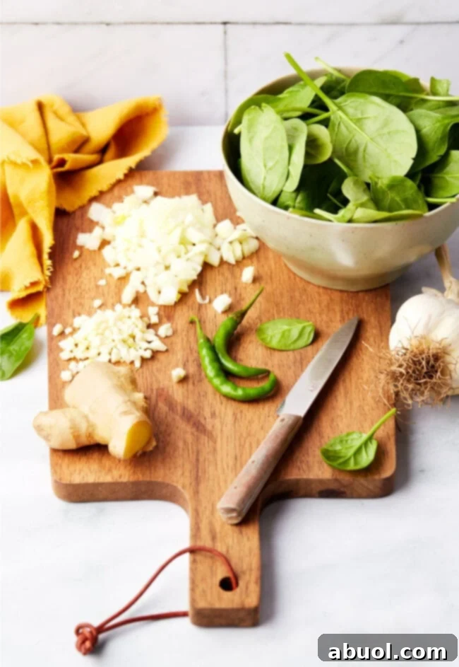 Ingredients for Saag Paneer on a wooden cutting board, prepped and ready to cook.