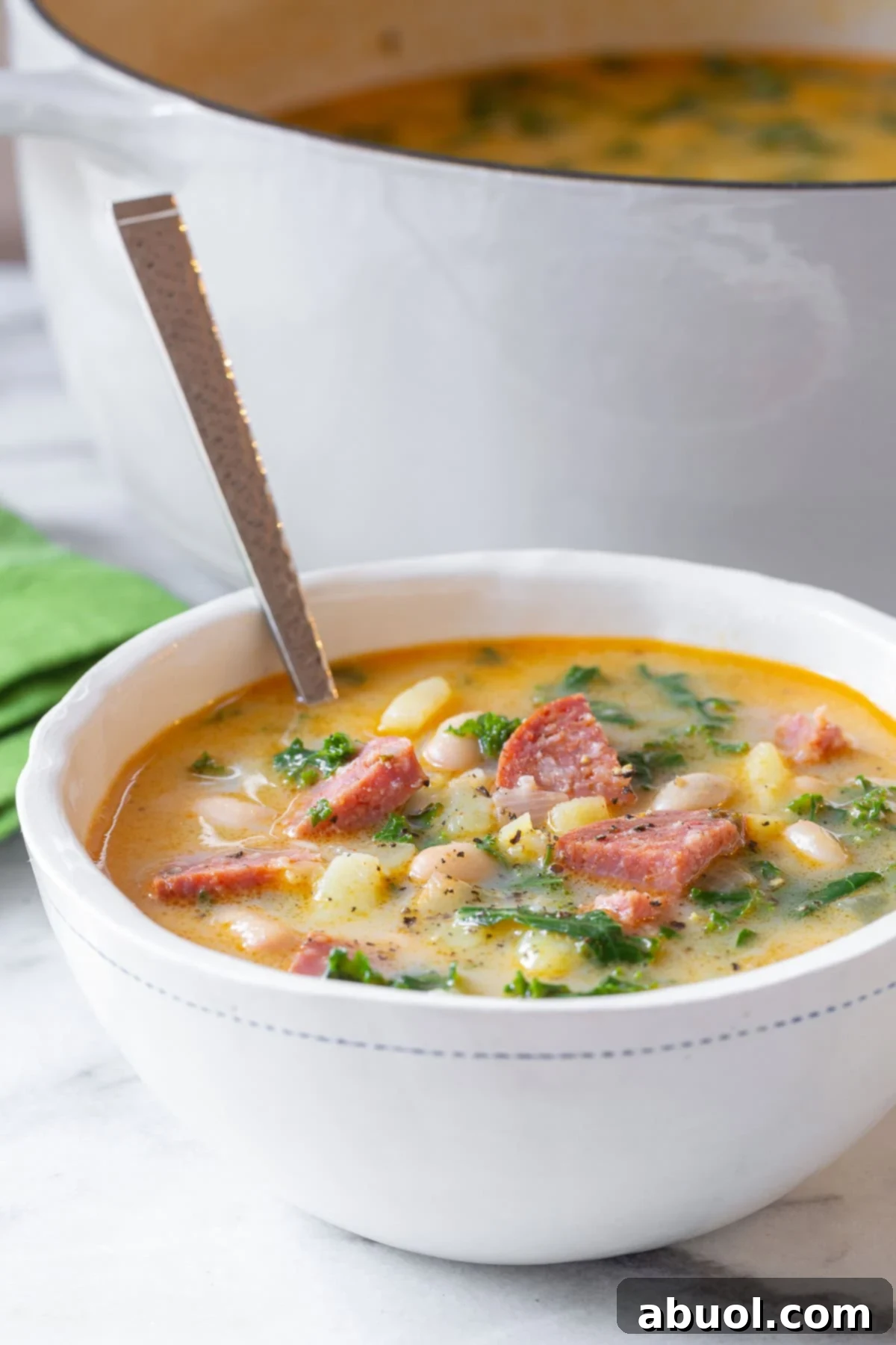 sausage and kale soup in white bowls