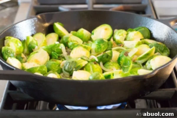 Halved fresh brussels sprouts in a cast iron skillet.