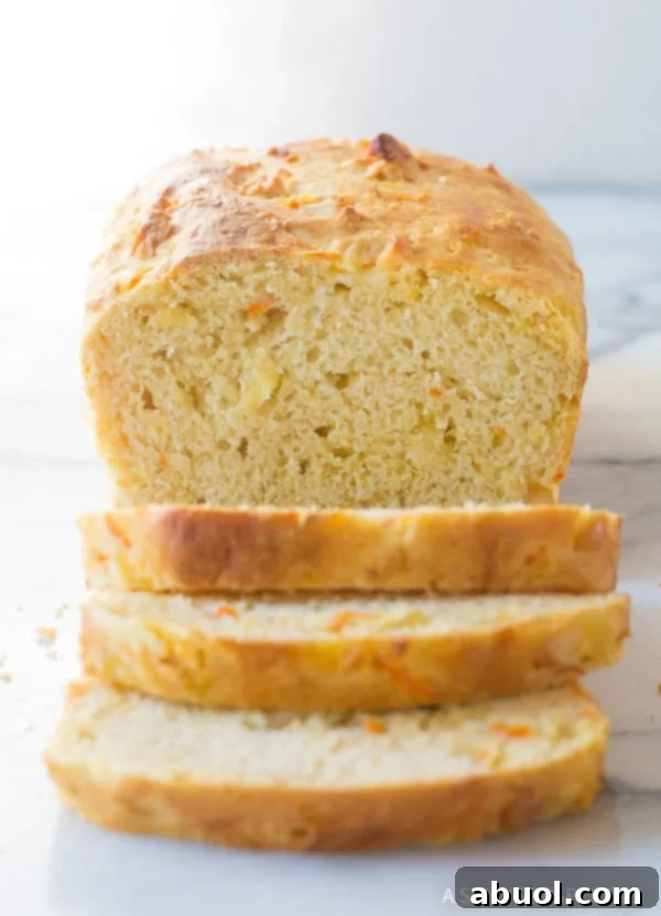 Pillowy Hawaiian Sweet Bread 2 A golden, chunky Hawaiian Luau Bread loaf with several slices artfully arranged, revealing the vibrant texture within.