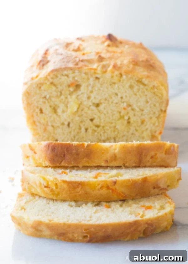 Pillowy Hawaiian Sweet Bread 11 A Hawaiian Luau Bread loaf with some slices artfully leaning off the end, showcasing its inviting texture.
