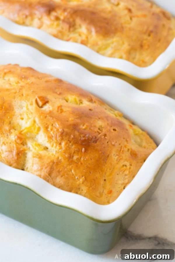 Pillowy Hawaiian Sweet Bread 9 Two perfectly baked loaves of Hawaiian bread resting in their loaf pans after being removed from the oven.