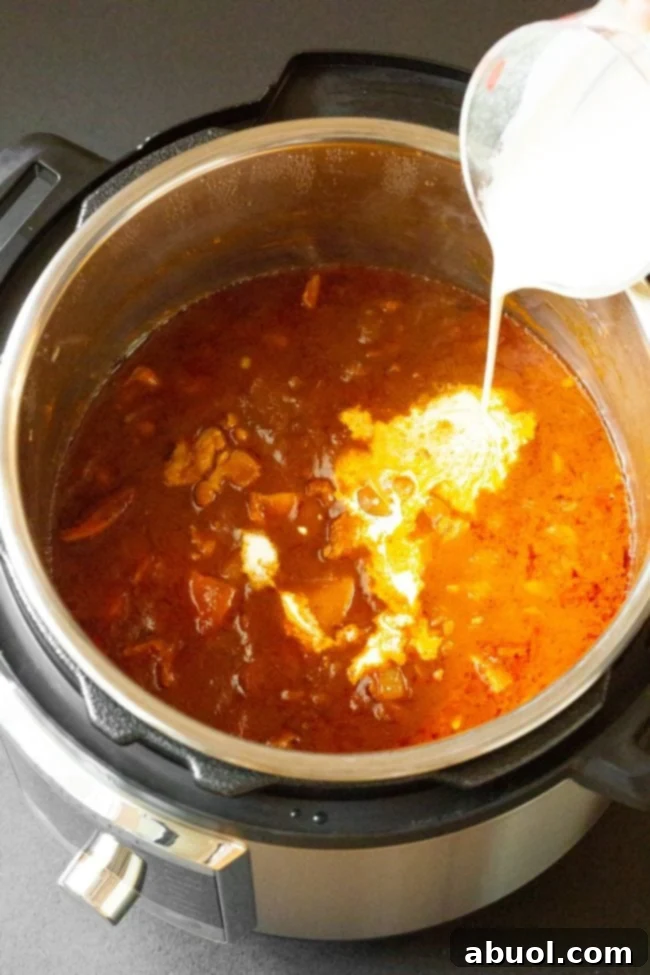 Heavy cream being poured into instant pot.