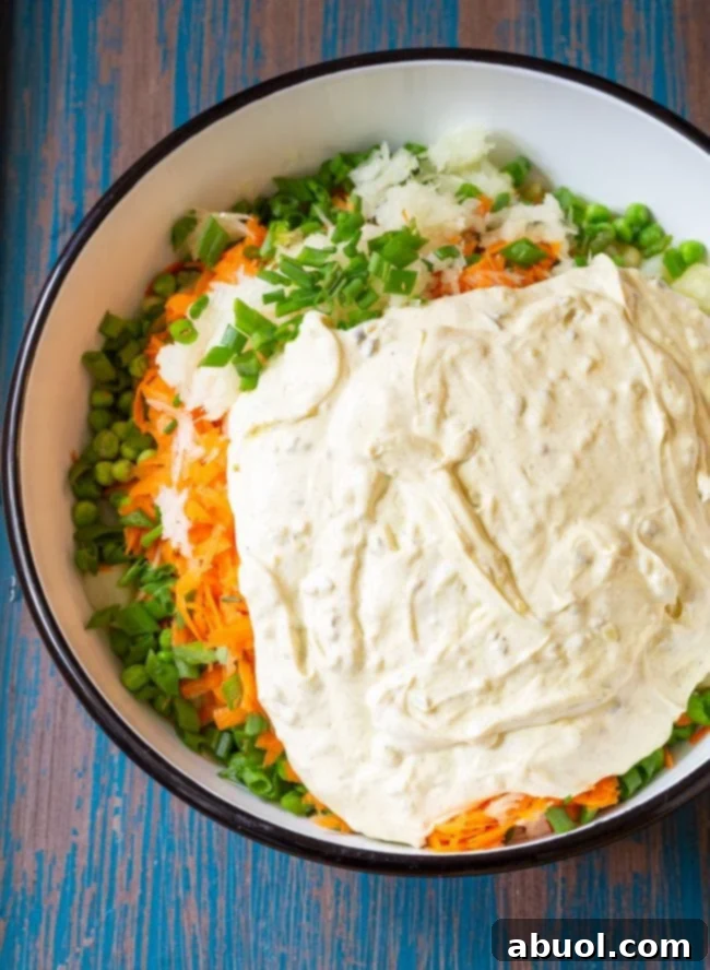 Ingredients for this potato pasta salad in a large mixing bowl with the dressing on top.