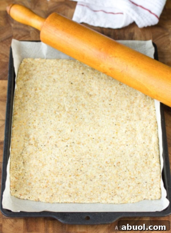 Baking sheet covered with thin layer of raw cracker dough.