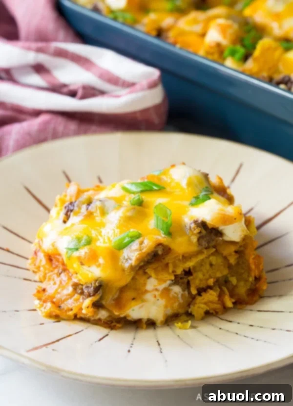 Closeup of a plated slice of Dorito casserole, showing perfectly melted cheese and meat.