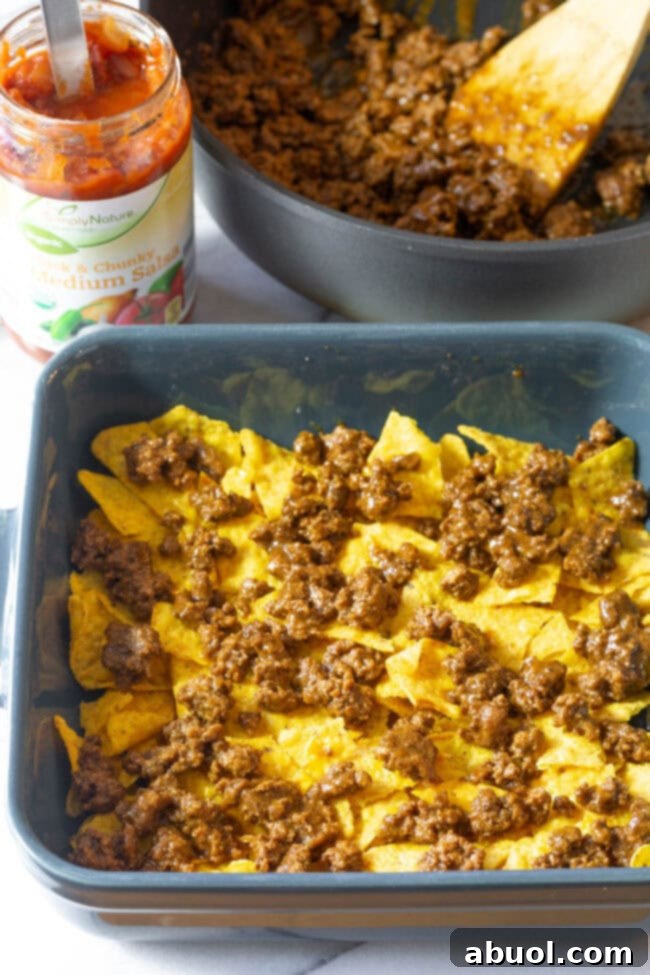 Doritos covered with cooked minced meat, seasoned and ready for the next layer.