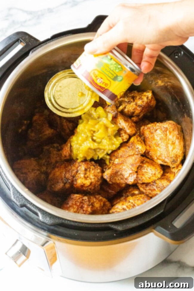 Crispy Instant Pot Carnitas 8 Green chiles added to the Instant Pot with other ingredients for Instant Pot Carnitas