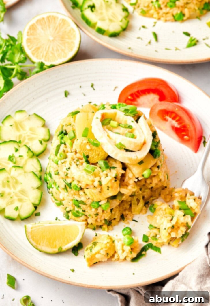 thai fried rice topped with green onions on plate.