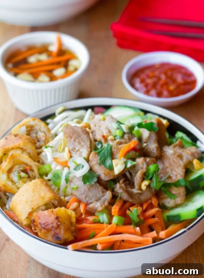 Bun Cha in a bowl with sauces in the background. 