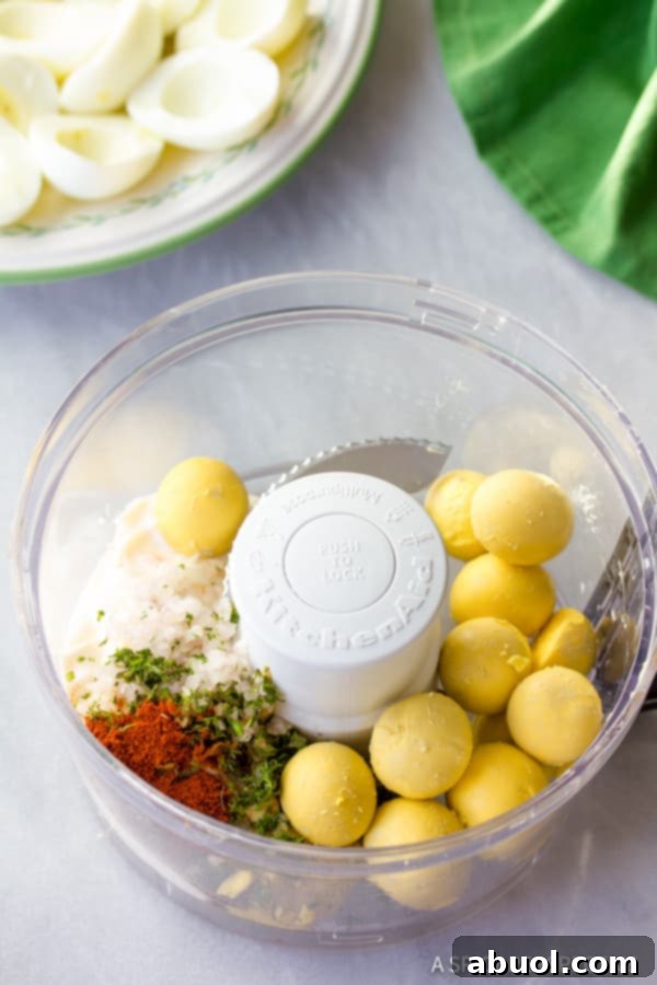Creamy deviled eggs filling being prepared in a food processor.
