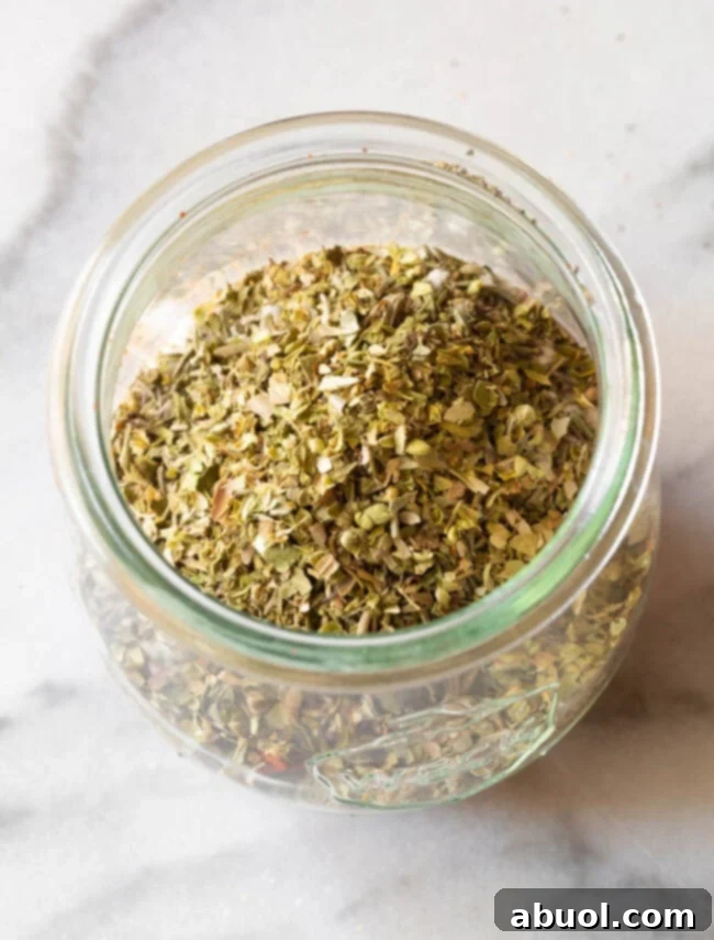 Overhead view of homemade blackened seasoning in a glass jar, highlighting the rich colors of the spices.