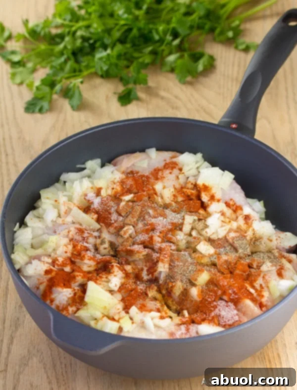 Chicken Paprikash in skillet with chopped vegetables and paprika