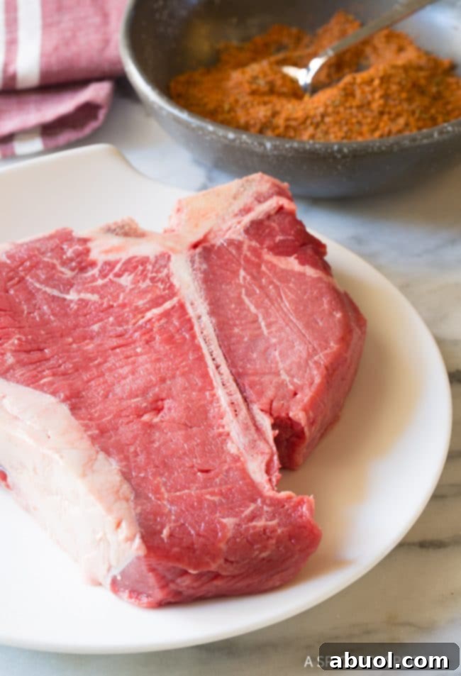 A hand gently rubbing the homemade seasoning blend onto a raw steak before cooking.