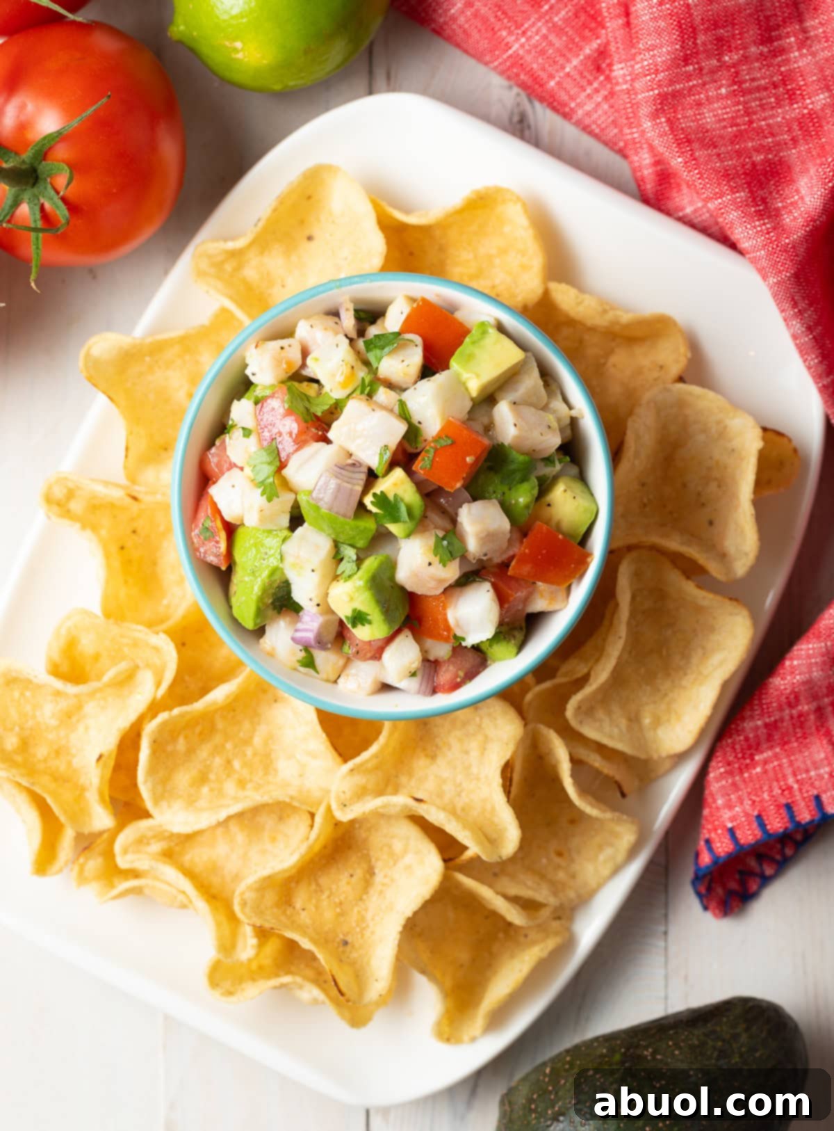 ceviche de pescado overhead shot in small bowl on platter with tortilla chip scoops