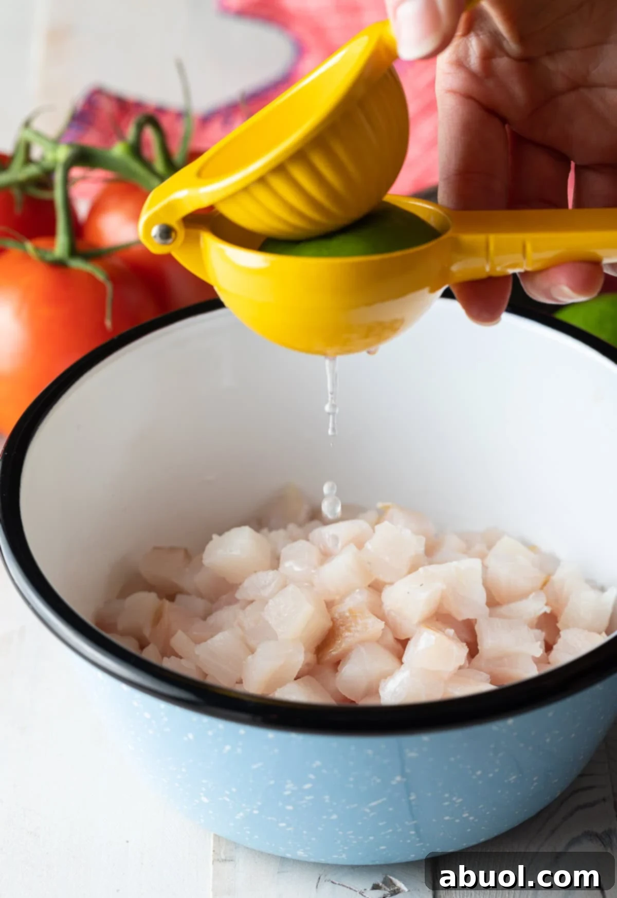 How to make ceviche - diced fresh fish in bowl with lime juice squeezed over the top