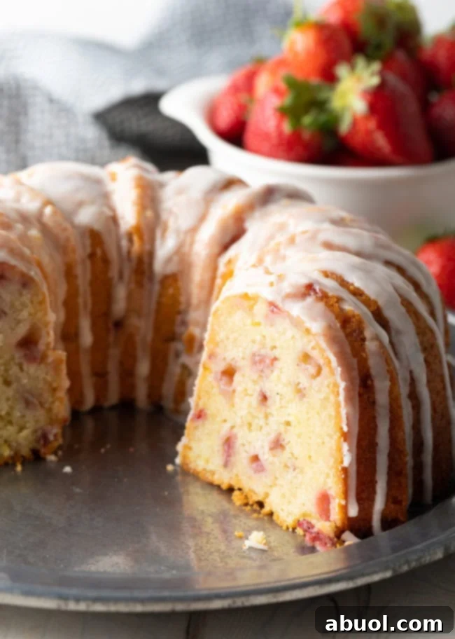 Freshly baked strawberry bundt cake with slice missing to show the inside.