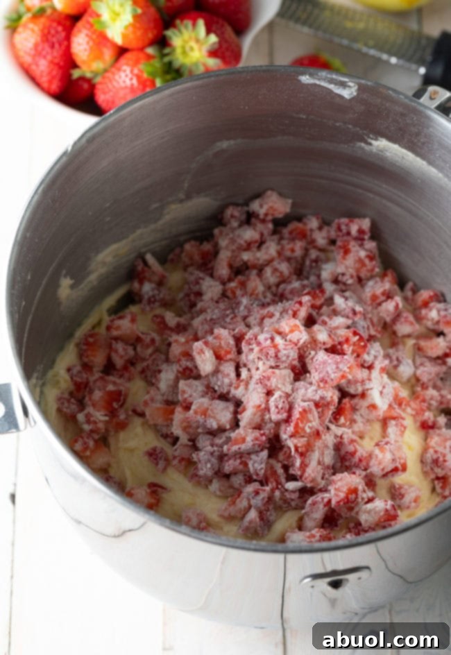 Strawberry bundt cake batter with fresh chopped strawberries on top.