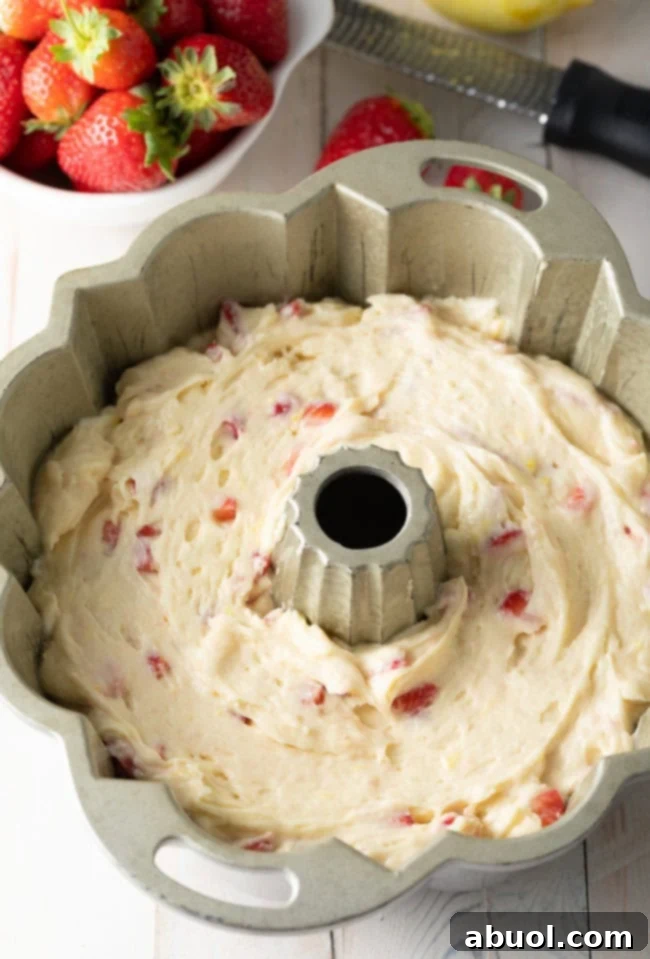 Strawberry cake batter in silver bundt pan before being baked.