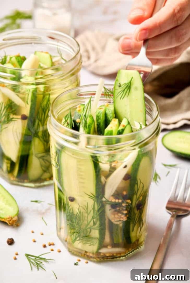 Hand reaching for a crisp dill pickle spear from a jar, showcasing the tempting texture