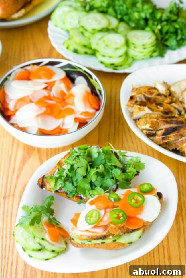 Vietnamese Banh Mi recipe - sandwiches artfully arranged on plates, piled high with fresh vegetables and herbs